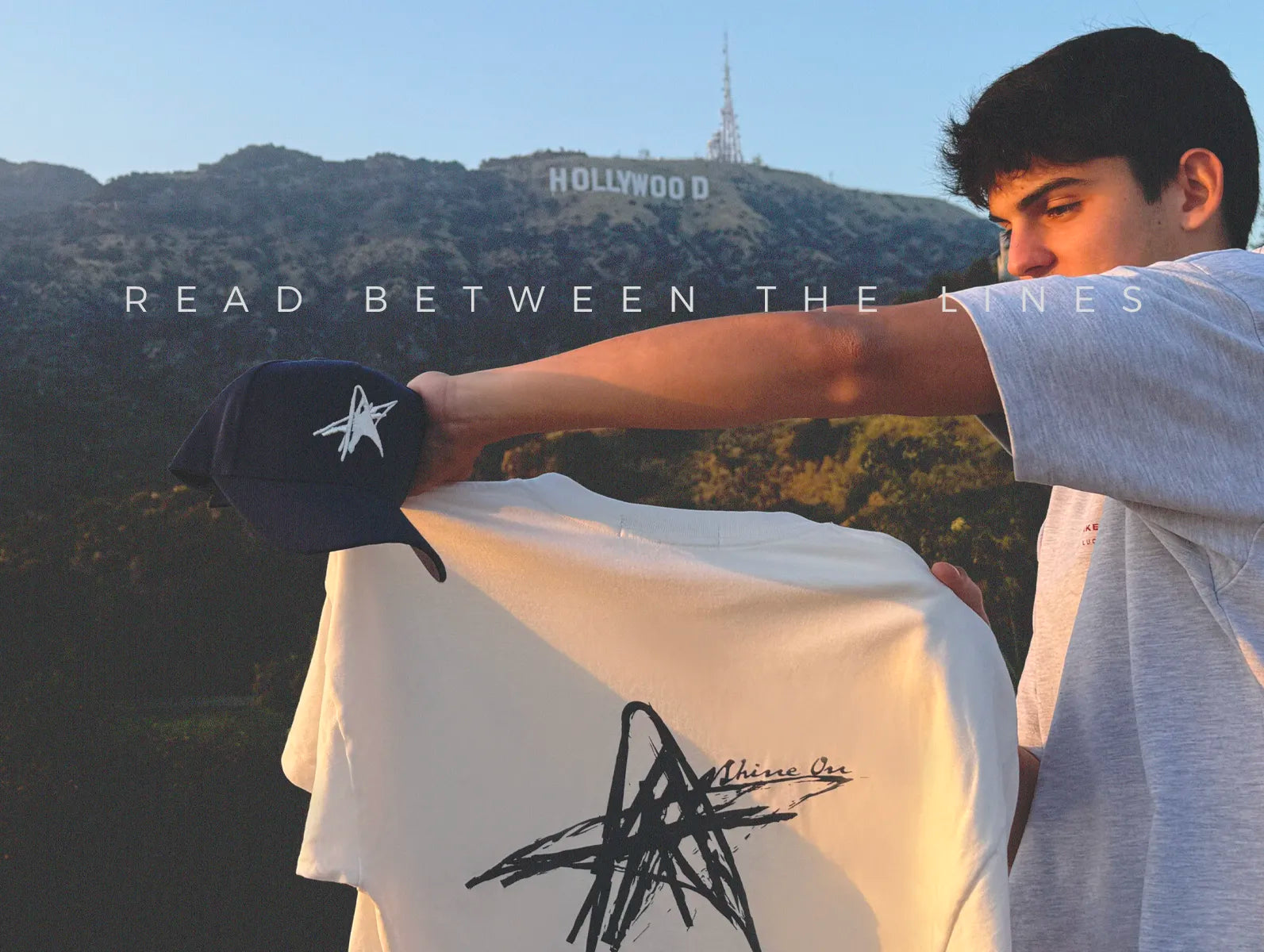 Load video: Dante Lucero in a light golf polo and navy Lucidity star cap, introducing the Read Between the Lines drop.